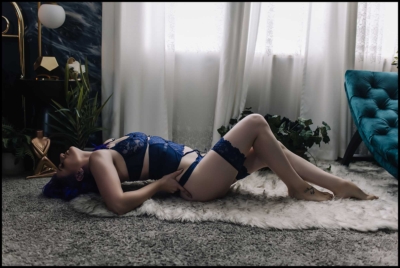 Image of woman in navy arching her back on fur rug
