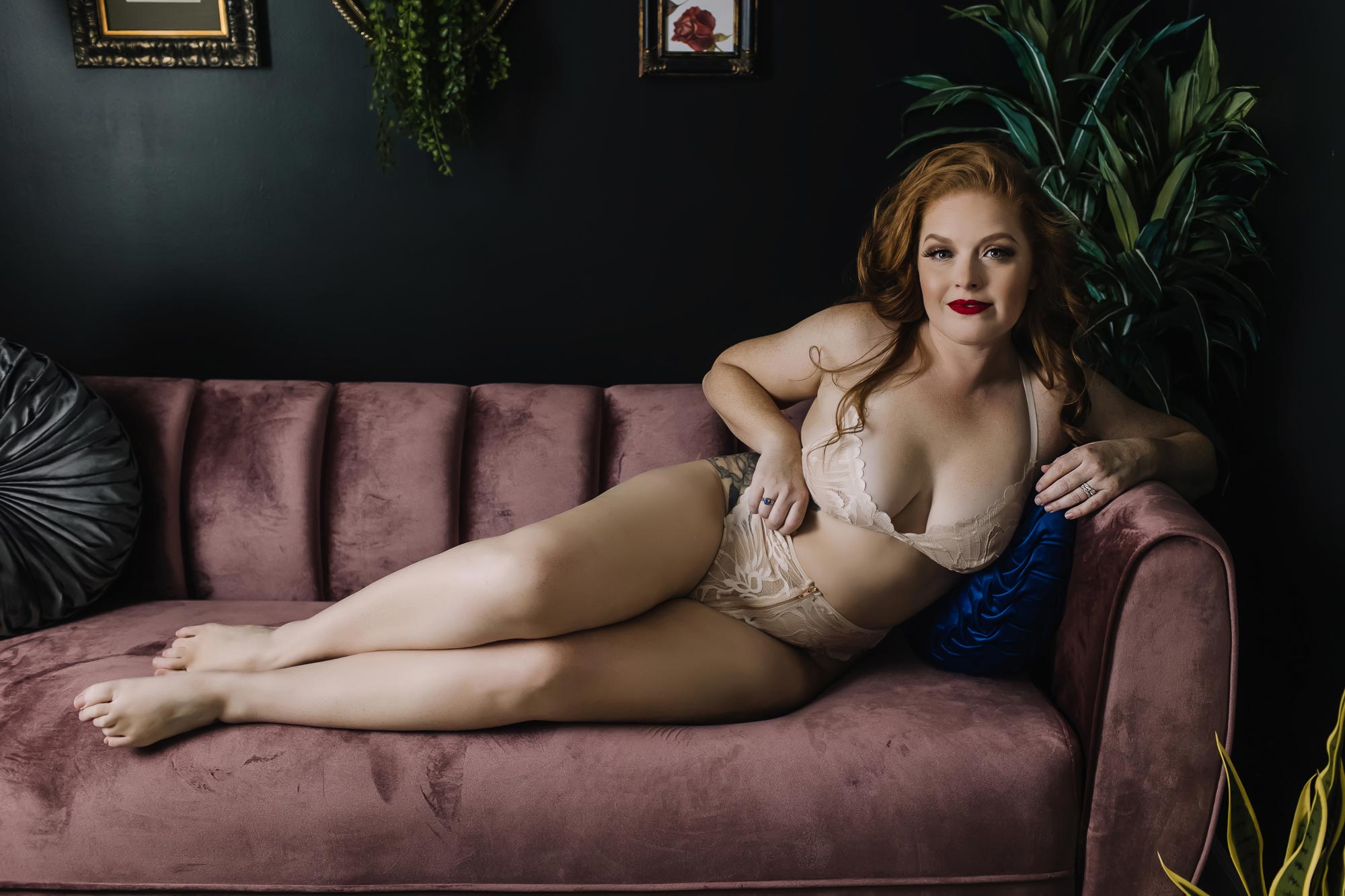 image of red head woman in lingerie on pink couch smiling at camera