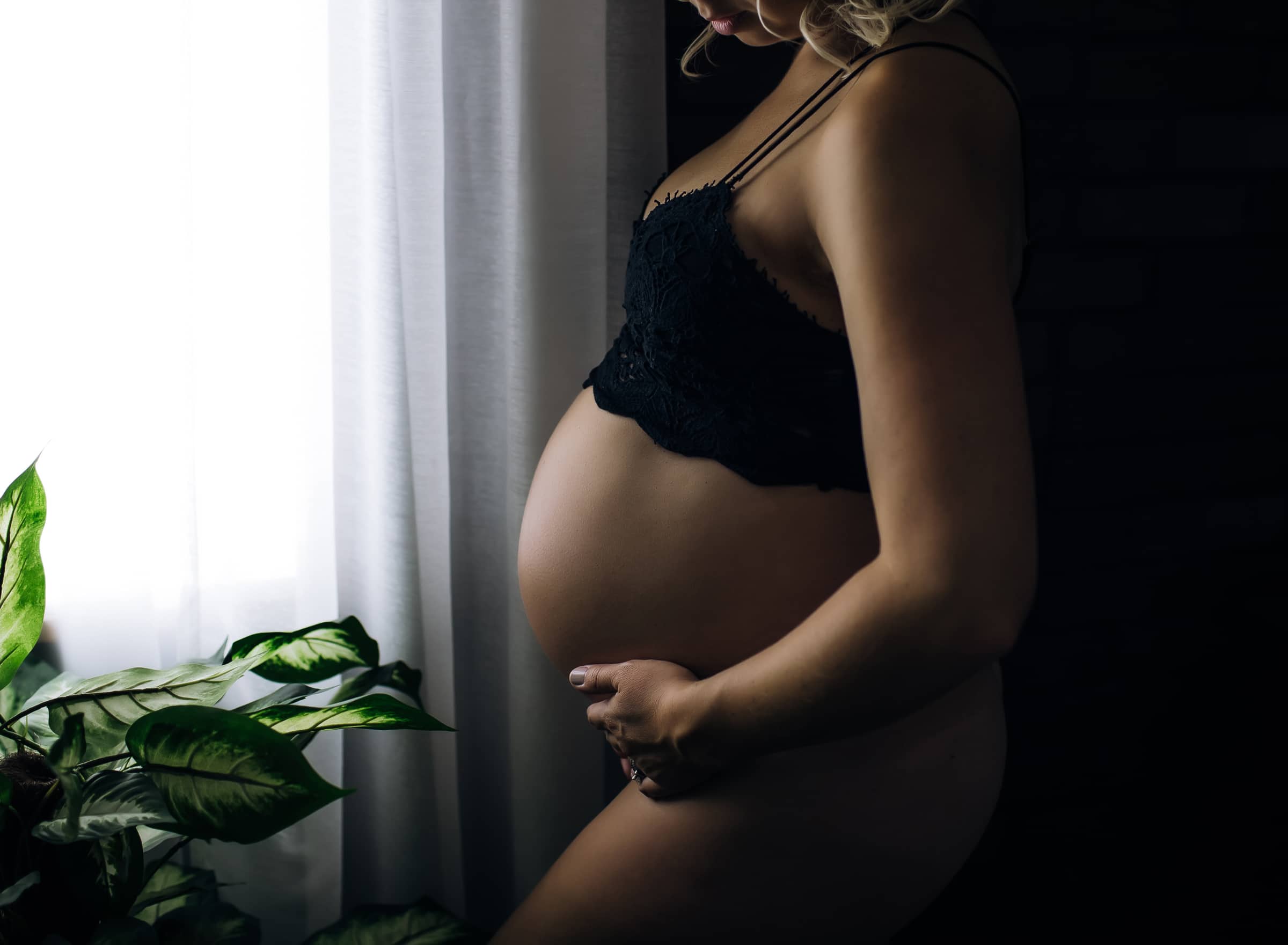 pregnant-woman-in-black-standing-in-front-of-window