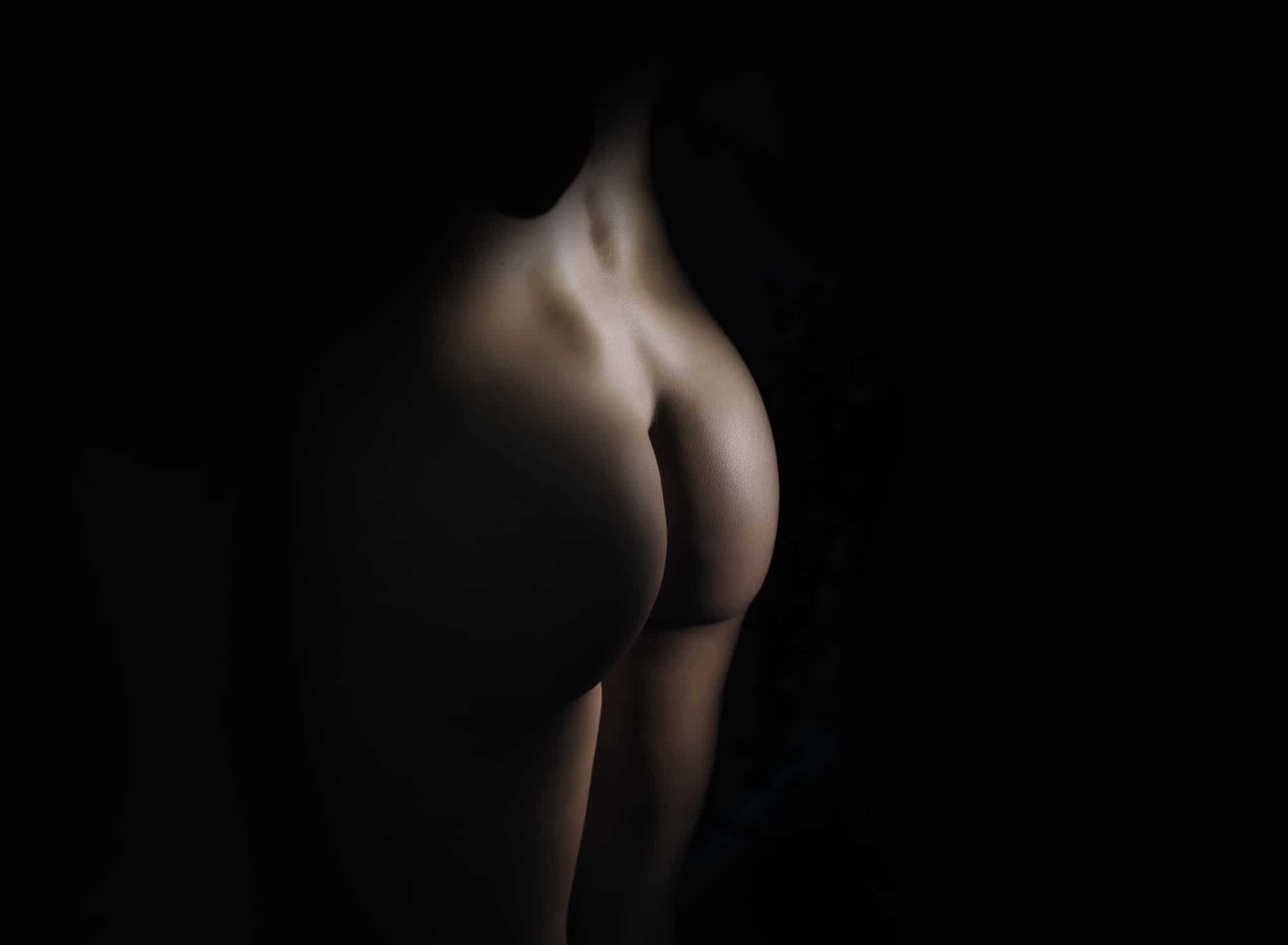 up close image of a nude-woman butt with light focused on her