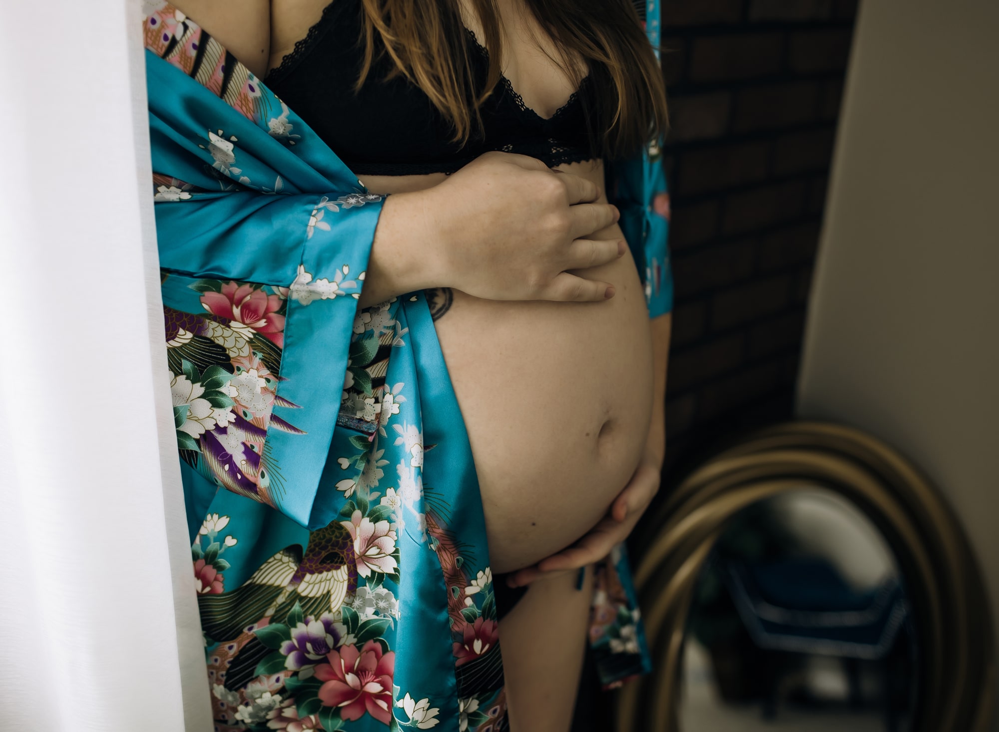 woman-in-blue-satin-robe-cradling-her-pregnant-belly