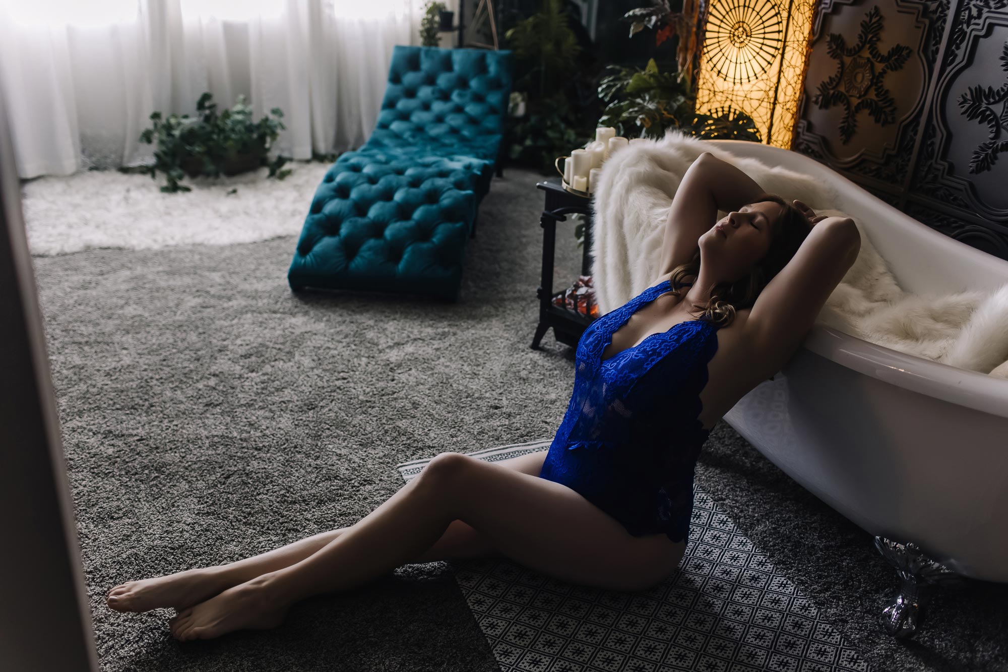 woman in blue sitting on floor arching back